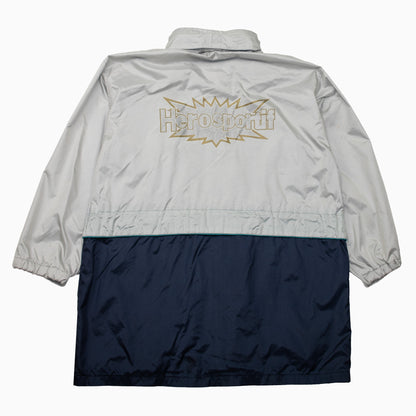 Herosportif-Windbreaker mit grauem Rücken, großem Logo und marineblauem unterem Bereich – Rückansicht.